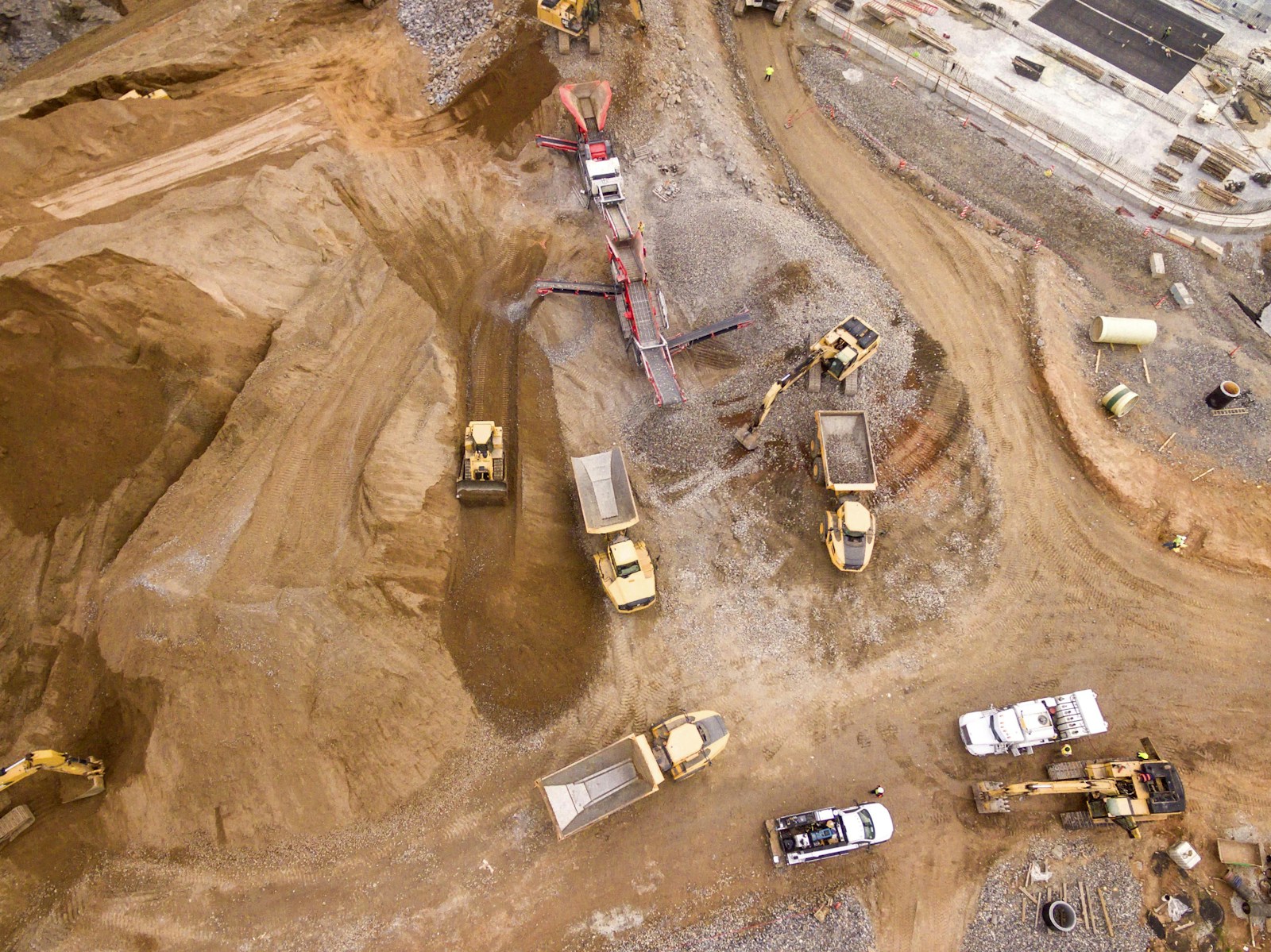 Aerial view of earthworks construction site with bulldozers and aggregate processing equipment - the kind of terrain where ground control point distribution determines mapping accuracy